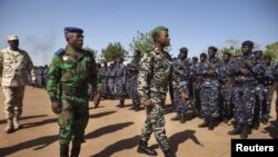 Ivory Coast army chief-of-staff Soumaila Bakayoko (L) and Malian army chief-of-staff Ibrahima Dahirou Dembele (C) inspect Malian troops at an air base in Bamako, January 16, 2013. 