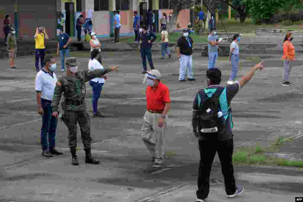 Un miembro del Ejército ecuatoriano pide a la ciudadanía respetar el distanciamiento social en la escuela Hugo Ortiz, durante las elecciones generales, en Guayaquil, Ecuador, el 7 de febrero de 2021.