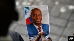 Una persona sostiene una fotografía del difunto presidente Jovenel Moïse durante una ceremonia fúnebre el 20 de julio de 2021, en el Museo y Cementerio Nacional en Puerto Príncipe, Haití. 