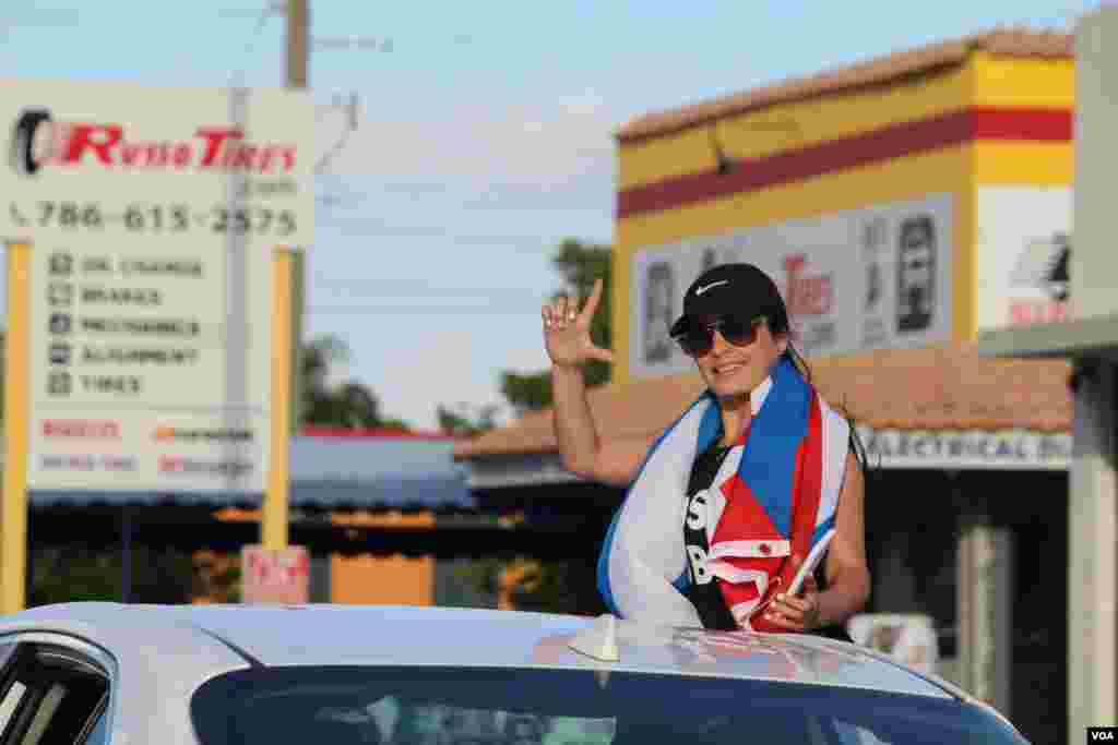 Una joven hace la señal de "Libertad" en camino a la manifestación a través de la Calle 8 en Miami, Florida, en apoyo a las protestas sucedidas el domingo 11 de julio de 2021. Foto: Luis F. Rojas, VOA.
