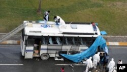 Forensic police cover a damaged police vehicle after a bomb went off near the country's ruling party offices in Turkey's largest city, Istanbul, March 1, 2012.