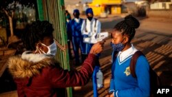 Une élève de l'école secondaire Winnie Mandela fait mesurer sa température avant la reprise des cours dans le canton de Tembisa, Ekurhuleni, le 8 juin 2020.