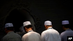 FILE - Chinese Hui Muslims pray during Eid al-Fitr prayers at Niujie Mosque in Beijing, July 18, 2015. Authorities in northwestern China were poised to begin demolition of a mosque Friday, despite protests by hundreds of members of the country's Muslim Hui ethnic minority determined to preserve the newly built structure.