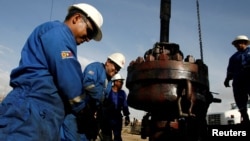 ARCHIVO - Trabajadores petroleros en Cabimas, en el estado occidental venezolano de Zulia. Estados Unidos acaba de aliviar sanciones económicas en esa industria y en la gasífera por 6 meses para alentar acuerdos políticos.