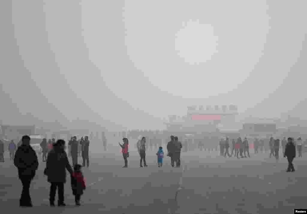 People visit the Olympic Park amid thick haze in Beijing, Feb. 25, 2014. 