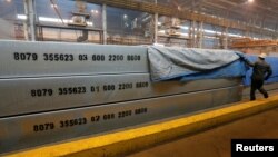 FILE - An employee removes a covering of 13-meter aluminium ingots at the foundry shop of the Rusal Krasnoyarsk aluminium smelter in Krasnoyarsk, Russia, July 27, 2016. Rusal is among Russian companies on a new U.S. sanctions list.