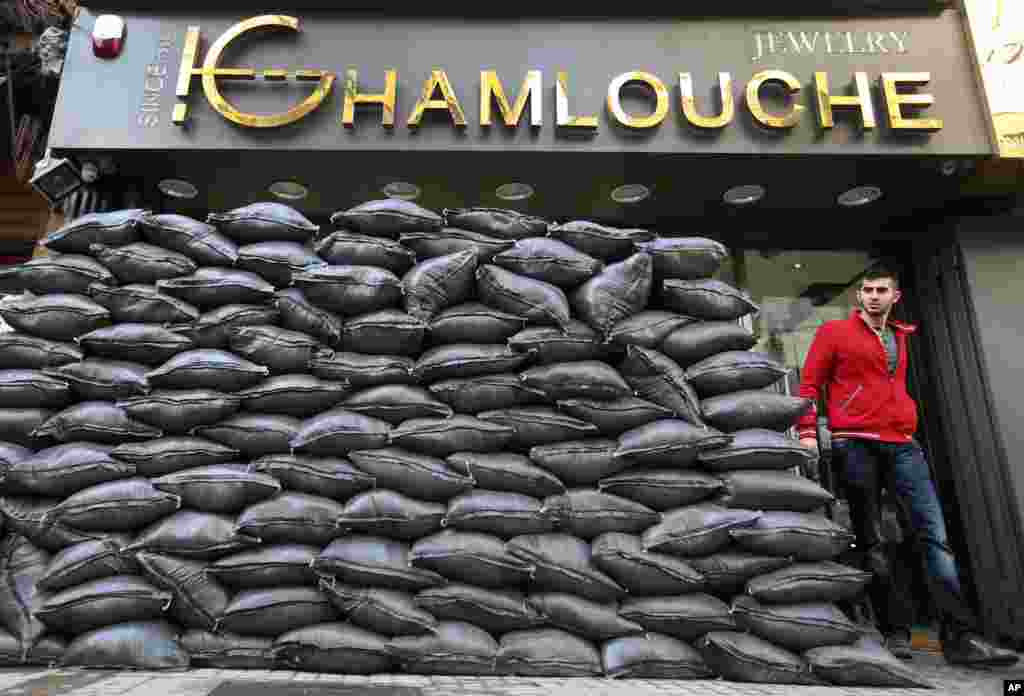 A Lebanese man walks past sand barriers that were set in front of a jewelry shop in a Shi'ite neighborhood in a southern suburb of Beirut. After a wave of car bomb attacks on Hezbollah's stronghold south of Beirut that left scores of people dead or wounded over the past three months, shop owners scared of more bombs have set up sand barriers in front of their shops to reduce damage.