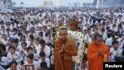 Thousands of mourners pray at the gates of the Royal Palace after the coffin of former king Norodom Sihanouk entered in Phnom Penh October 17, 2012. Tens of thousands poured into Cambodia's capital to witness the procession on Wednesday.