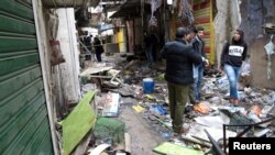Iraqi security forces inspect the site of a bomb attack at a market in central Baghdad, Iraq, Dec. 31, 2016