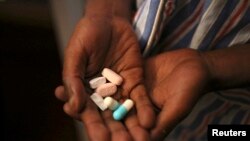 Nine-year-old Tumelo shows off antiretroviral (ARV) pills before taking his medication at Nkosi's Haven, south of Johannesburg, Nov. 28, 2014. Nkosi's Haven provides residential care for destitute HIV-positive mothers and their children, whether HIV-posit