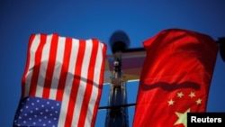 Bendera Amerika Serikat dan China berkibar dari tiang lampu di kawasan Chinatown Boston, Massachusetts, AS, 1 November 2021. (Foto: REUTERS/Brian Snyder)