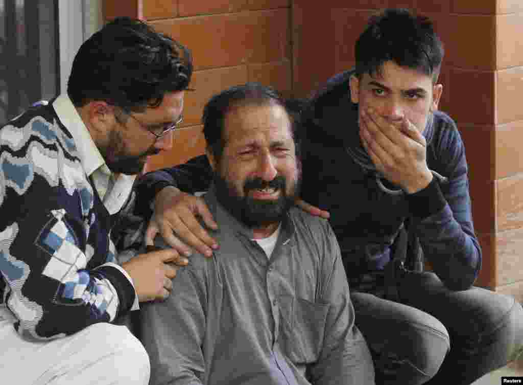 Relatives of a student, who was injured during an attack by Taliban gunmen on the Army Public School, comfort each other outside Lady Reading Hospital in Peshawar, Dec. 16, 2014.