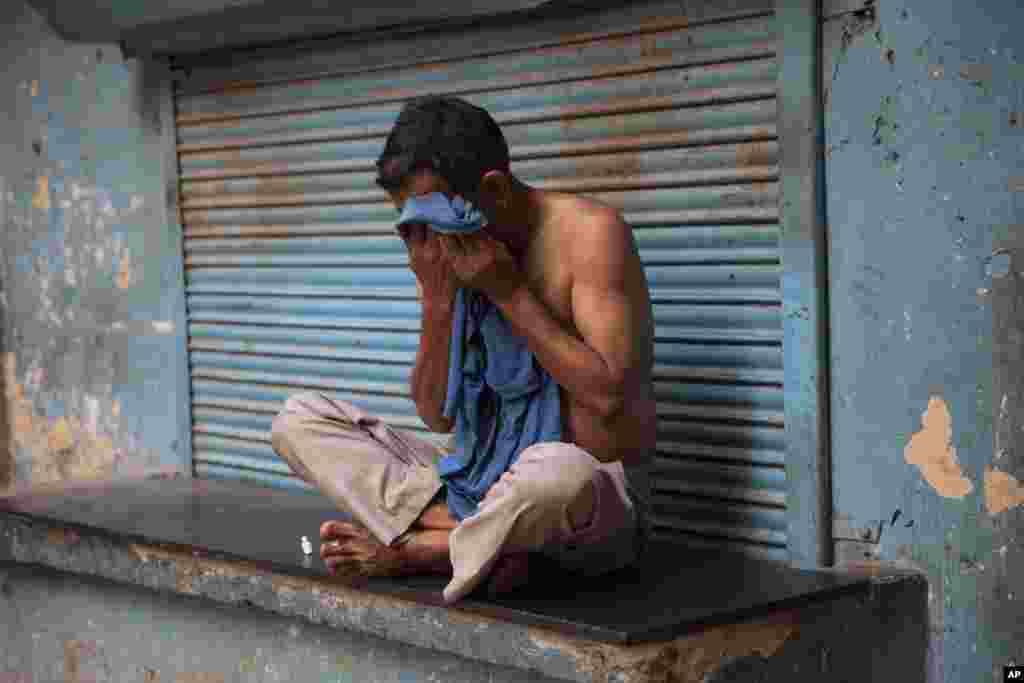 As a heat wave tightens its grip over most parts of the country, a man wipes sweat off his face in New Delhi, May 24, 2015. 