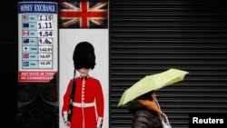 A pedestrian walks past a money exchange sign in central London, Britain, Jan. 16, 2017.