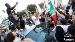 Des protestataires chantent autour d'une voiture lors d'une manifestation contre le candidat républicain à la présidentielle américaine Donald Trump à la fin de son meeting de campagne à San Jose, Californie, États-Unis, 2 juin, 2016. REUTERS / Stephen Lam - RTX2FFON