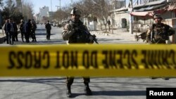 Fuerzas de seguridad afganas vigilan el sitio del ataque en Kabul, el 28 de diciembre, que dejó 41 muertos y 84 heridos.