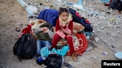 Djeca se odmaraju napolju, dok Palestinci stižu u Rafah nakon što su evakuisani iz bolnice Nasser u Khan Younisu zbog izraelske kopnene operacije, u južnom pojasu Gaze, 15. februara 2024.