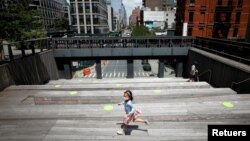 Una niña transita por una calle de la cudad de Nueva York usando una máscara protectora contra el coronavirus, en esta foto de julio de 2020. 