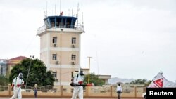Une équipe médicale nettoie le terrain d'aviation, pour prévenir la propagation de la maladie à coronavirus (COVID-19), à l'aéroport international de Juba, à Juba, au Sud Soudan, le 5 avril 2020. 