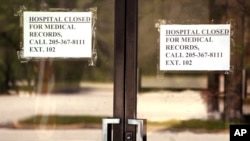 In this March 26, 2020, photo, closed signs hang on a recently closed Pickens County Medical Center in Carrollton, Ala. The hospital is one of the latest health care facilities to fall victim to a wave of rural hospital shutdowns across the United States