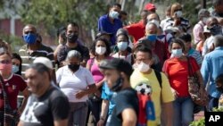 Personas hacen fila junto a una cancha de baloncesto en el barrio 23 de Enero para vacunarse durante una campaña de vacunación contra el COVID-19 en Caracas, el 9 de junio de 2021.