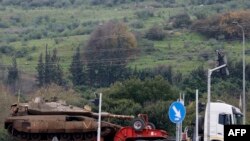 An Israeli military truck transports a tank in the Upper Galilee in northern Israel near the border with Lebanon on January 5, 2024.