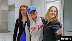 Rahaf Mohammed al-Qunun (tengah) ditemani Menteri Luar Negeri Kanada Chrystia Freeland (kanan), tiba di Bandara International Toronto Pearson International Airport di Toronto, Ontario, Kanada, 12 Januari 2019. 