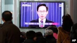 韓國人民2013年2月19日在韓國首爾的火車站觀看電視實況轉播總統李明博在發表離職前全國講話。