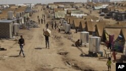 Syrian refugees walk through the Dumez refugee camp in Dahuk, northwest of Baghdad, Iraq, August 13, 2012. 