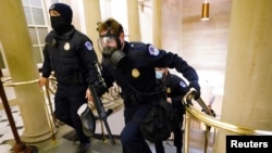 Petugas Kepolisian Gedung Kongres AS bersiaga menghadapi pedemo yang menerobos masuk ke gedung saat sidang pengesahan hasil pilpres AS 2020 di Capitol Hill, Washington, 6 Januari 2021.