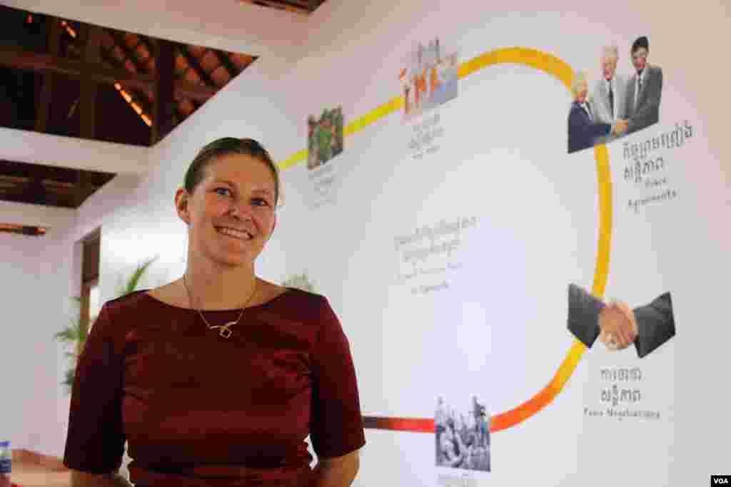 Nikki Singer, Director of Cambodia Peace Museum, stands in front of a painting on the wall, portraying of the brief history of Cambodia as she observes the gallery. (Rithy Odom/VOA)