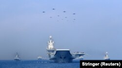 中國海軍遼寧號航母與軍艦和戰機在進行軍事表演。（2018年4月12日）