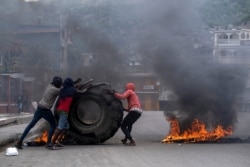 Grupos de manifestantes incendian neumáticos en Cabo Haitiano, Haití, durante una protesta el 22 de julio de 2021 por el asesinato del presidente Jovenel Moise.