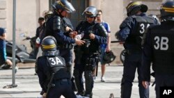 Des policiers assistent un homme blessé dans des affrontements dans le centre de Marseille, France, 11 juin 2016. (AP Photo / Darko Bandic)