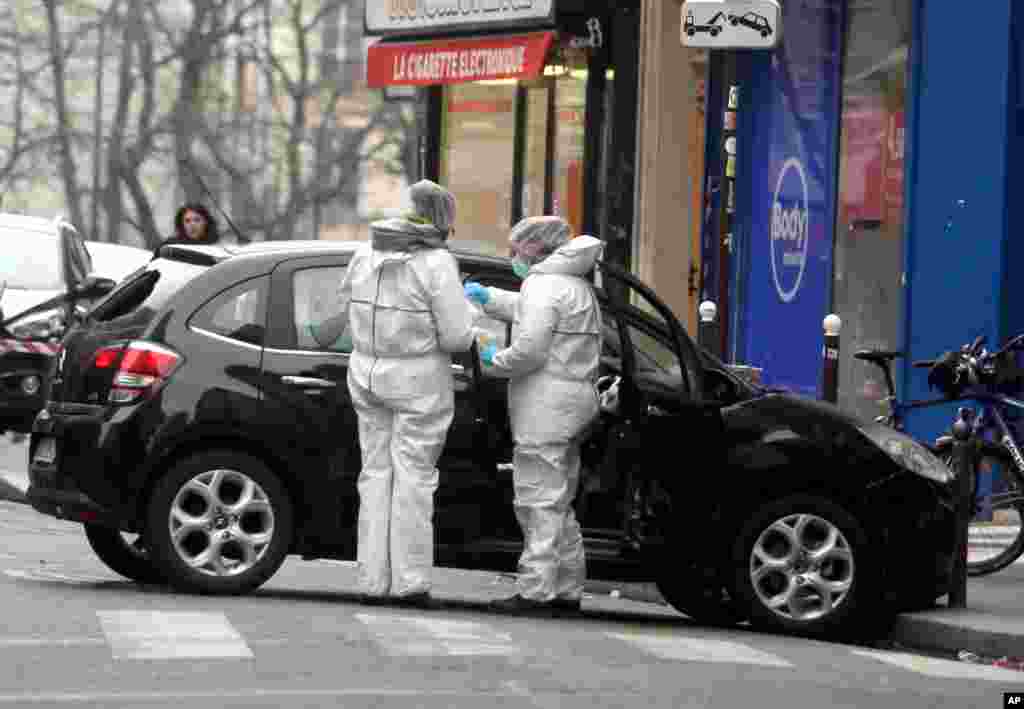Forensic experts examine the car believed to have been used as the escape vehicle by gunmen who attacked the French satirical weekly Charlie Hebdo's office in Paris, Jan. 7, 2015.