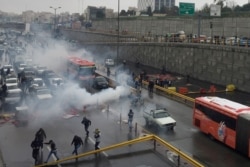 FILE - Riot police try to disperse protesters as they rally on a highway against increased fuel prices, in Tehran, Iran, Nov. 16, 2019.
