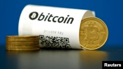 Foto ilustrasi kertas Bitcoin (mata uang virtual) dengan kode "QR" dan beberapa koin mata uang. 
