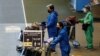 Pria yang mengenakan pakaian pelindung berjalan di halte bus di bandara internasional Narita pada hari pertama penutupan perbatasan untuk mencegah penyebaran varian virus corona baru omicron di Narita. (Foto: Reuters)