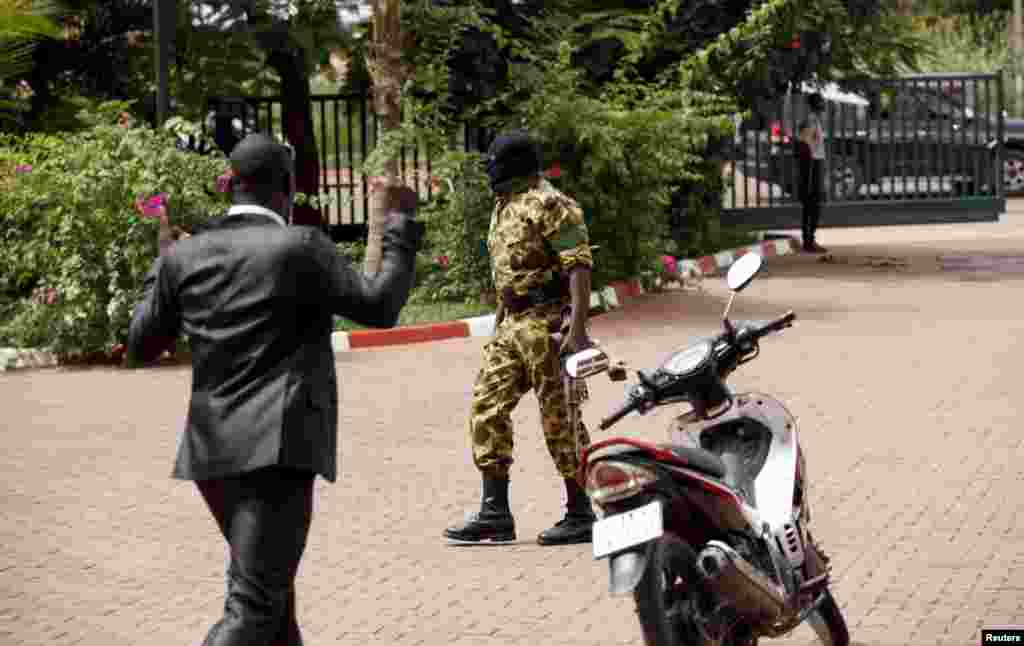 A presidential guard member wearing ski mask arrives at the Laico hotel in Ouagadougou, Burkina Faso, September 20, 2015. Pro-coup demonstrators in Burkina Faso on Sunday invaded the hotel due to host talks aimed at hammering out the details of a deal to