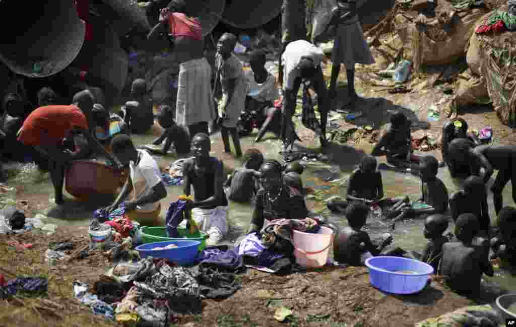 Des personnes déplacées se baignent et nettoient leurs habits dans une rivière dans l’enceinte d’une base de l’ONU, après de récents affrontements à Juba, 27 décembre 2013. (AP Photo/Ben Curtis, Archives).