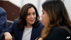 FILE - Democratic presidential candidate Sen. Kamala Harris, D-Calif., left, speaks with Astrid Silva, right, at an immigration roundtable at the University of Nevada, Las Vegas in Las Vegas, June 14, 2019.