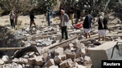 People walk on the rubble of a house destroyed by a Saudi-led airstrike in Sana'a, Yemen, Feb. 2, 2017. 