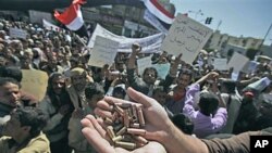 An anti-government protester displays bullet shells, claiming they were fired at demonstrators Tuesday night by Yemeni government supporters, killing at least one demonstrator, while demanding resignation of President Ali Abdullah Saleh, in Sanaa, Yemen,