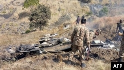 巴基斯坦士兵站在一架印度战斗机残骸旁。（2019年2月27日）