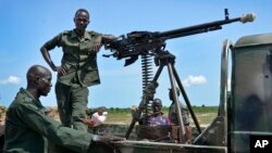 Les soldats du gouvernement montent la garde près de leur véhicule sur les lignes de front dans la ville de Kuek, dans le nord de l'état du Haut-Nil, au Sud-Soudan.