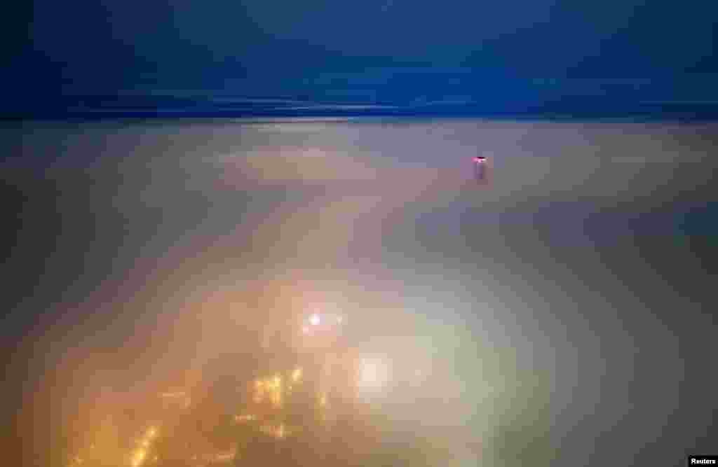 A drone view shows a tower of Abu Dhabi Plaza sticking out of a thick blanket of fog in Astana, Kazakhstan, Dec. 1, 2024.