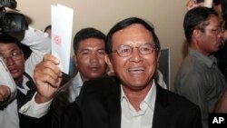 FILE PHOTO - Opposition Cambodia National Rescue Party President Kem Sokha shows off his ballot before voting in local elections in Chak Angre Leu on the outskirts of Phnom Penh, Cambodia, Sunday, June 4, 2017. 