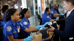 Transportation Security Administration employees check passengers' identifications at a security checkpoint at LaGuardia Airport in New York, Thursday, May 26, 2016. (AP Photo/Seth Wenig)