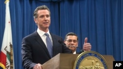 ARSIP – Gubernur California, Gavin Newsom, kiri diapit oleh Jaksa Agung, Xavier Becerra, kanan, menjawan pertanyaan dalam sebuah konferensi pers di Sacramento, California, 15 Februari 2019 (foto: AP Photo/Rich Pedroncelli)