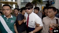 Thai policemen arrest an anti-coup protester (C) during a demonstration at a shopping mall in Bangkok, June 22, 2014. 